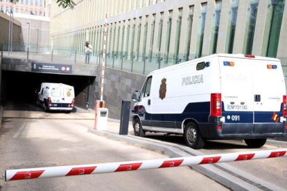Pla mitjà des de darrere de dues furgonetes de la policia espanyola entrant al parking subterrani de la Ciutat de la Justícia, el 25-5-18.