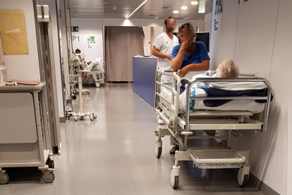Estado de Urgencias miércoles a las dos del mediodía: dos pacientes en el pasillo, acompañados de familiares.