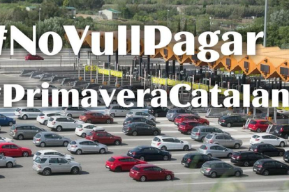 Una fotografia d'un peatge amb vehicles amb el lema 'No vull pagar' #Primaveracatalana.