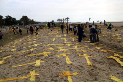 Imatge de creus esteses, fetes amb tovalloles, a la platja de Mataró.