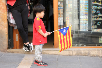 El fill del propiertari d'un basar anava vestit amb la samarreta de la selecció espanyola i una estelada a la mà.