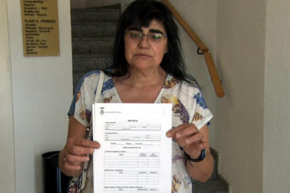 Maria Rosa Piñol con el formulario de daños que reparte el Ayuntamiento de Flix para inventariar los desperfectos del fuego.