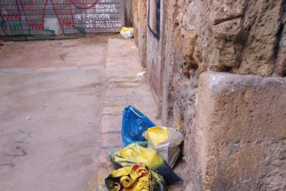 Una bolsa de basura dejada en el suelo pintada de amarillo.