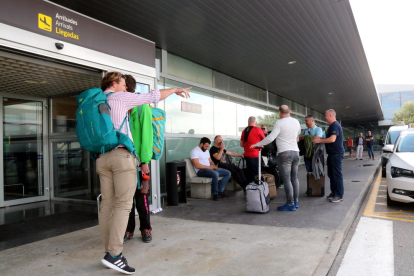 Turistes amb maletes a la porta de l'Aeroport de Reus.