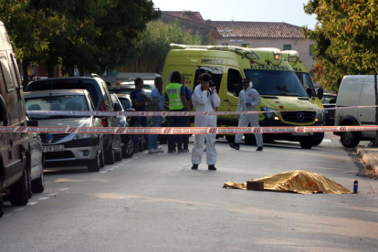 El cos de la víctima tapat a terra i els Mossos fent tasques d'investigació.