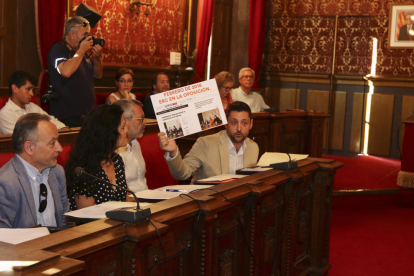 Viñuales muestra un cartel que hace referencia a las declaraciones de Ricomà en el 2016 sobre la distribución de los miembros de las empresas.
