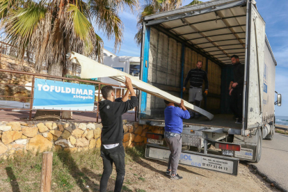 Uns operaris carreguen una furgoneta amb material que hi havia a la terrassa del restaurant.