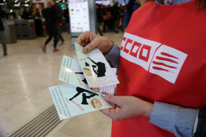 Una sindicalista de CCOO reparte folletos en estaciones de tren y paradas de metro de Barcelona.