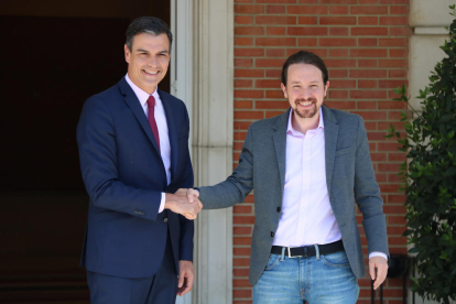 El presidente del gobierno electo, Pedro Sánchez, y el líder de Podemos, Pablo Iglesias, encajando manos en La Moncloa.