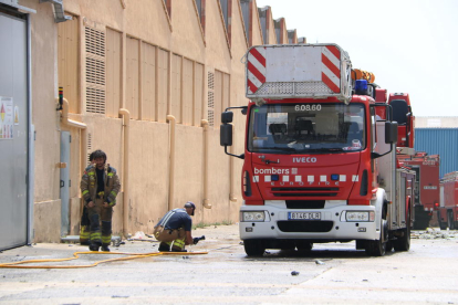 Pla tancat dels efectius dels bombers treballant per extingir l'incendi en una nau del polígon Entrevies de Tarragona. Imatge del 7 de juliol del 2019 (Horitzontal).