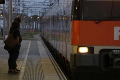 Dos passatgers esperen el tren a l'estació de Mataró, durant la jornada d'aturada general a Catalunya.