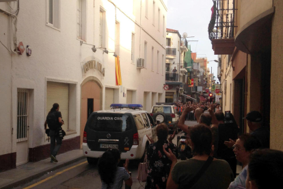 Dos vehicles de la Guàrdia Civil esperen els últims agents pendents de desallotjar l'Hotel Vila de Calella.
