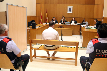 Imagen del policía acusado, sentado de espaldas, en la sala de vistas de la Audiencia de Barcelona.