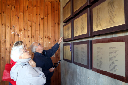 Imagen de Jean René, con algunos familiares, buscando el nombre de su padre, Glaussel René, muerto en la Batalla del Ebro, en las placas de homenaje a las víctimas