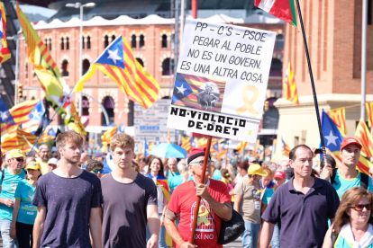 Manifestants a la plaça d'Espanya amb una pancarta contra PSOE, Cs i PP.