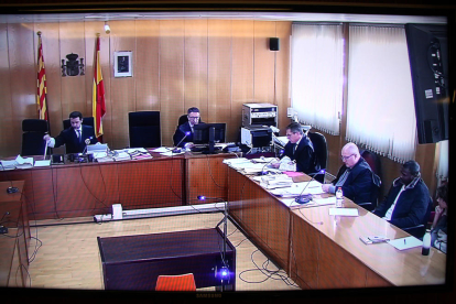 Captura de pantalla del senyal institucional del judici que es fa a l'Audiència de Tarragona contra l'acusat de matar una noia a Salou, assegut a la dreta.