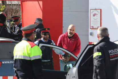 Los agentes llevándose a uno de los detenidos.