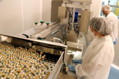 Treballadors de Pharmalink, amb planta de producció a Vilabella, amb una màquina de fabricació d'unes innovadores càpsules que ajuden a conciliar el son.