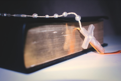 Imagen de una Biblia con un rosario.