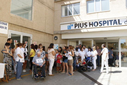 Plano general de una cincuentena de trabajadores de Pius Hospital de Valls concentrados delante de las puertas del centro hospitalario.