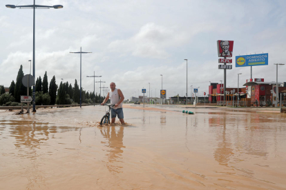 Un hombre atraviesa una vía totalmente inundada al pueblo murciano de San Javier.