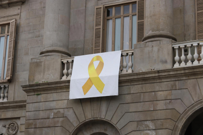 Pla mig de la pancarta amb el llaç groc que hi ha a la façana de l'Ajuntament de Barcelona.