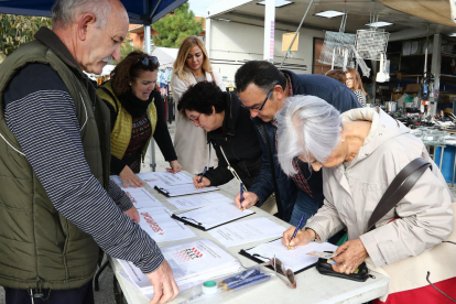 Fernández, tercera per l'esquerra, i tres persones en el moment de signar el document.