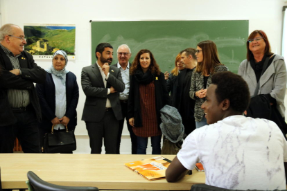 Els consellers d'Ensenyament i de Treball, Afers Socials i Famílies, Josep Bargalló i Chakir el Homrani, en una visita per un pla pilot a Tarragona, amb un jove africà assegut a primera fila.