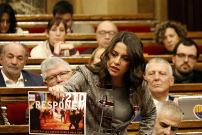 La líder de Cs, Inés Arrimadas, ensenyant un cartell que crida a mobilitzar-se el 21-D, al ple del Parlament.