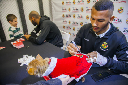 Luis Suárez, signant una peça de roba d'un gos que també va voler el seu autògraf.