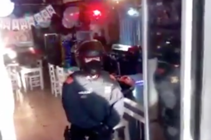 Imagen de un antidisturbios en la puerta del bar de l'Ampolla.