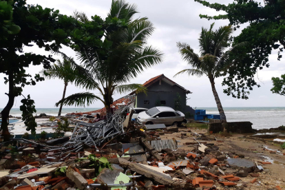 Pilas de escombros y un coche amontonados en la playa de Carita, en Pandeglang.