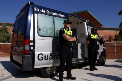 Pla obert de dos agents de la Guàrdia Urbana de Tarragona al costat d'una oficina mòbil de denúncies, davant el centre cívic de Torreforta. Imatge del 23 d'octubre del 2018
