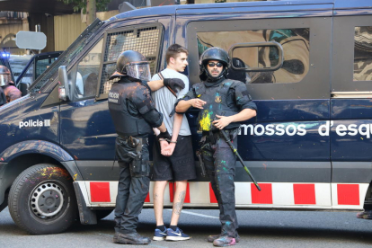 Imatge d'un jove detingut per part d'un grup de Mossos d'Esquadra.