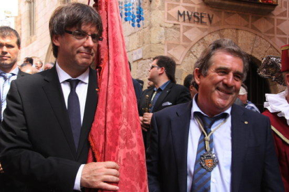 El presidente de la Generalitat, Carles Puigdemont, lleva la bandera de la Villa Ducal al lado del alcalde de Montblanc, Josep Andreu, en una imagen de archivo.