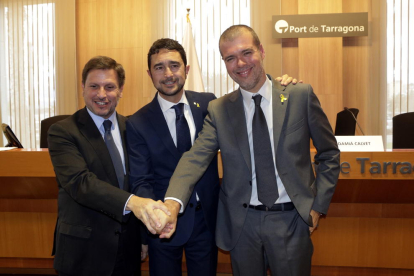 E conseller de Territorio y Sostenibilidad, Damià Calvet, encajando las manos con el presidente saliente del puerto de Tarragona, Josep Andreu (izquierda), y el futuro presidente, Josep Maria Cruset (derecha).