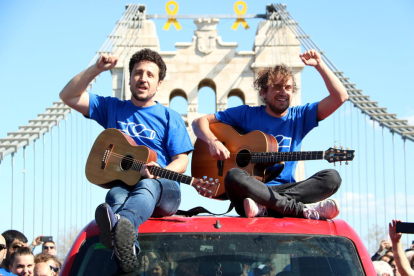 Pla obert del cantant de Pepet i Marieta, Josep Bordes, i d'un membre del grup damunt d'un vehicle durant el rodatge del videoclip 'La força de l'Ebre', al Pont d'Amposta. Imatge del 2 de març del 2019 (Horitzontal).