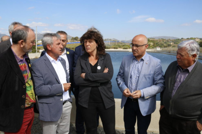 La consellera Teresa Jordà, con los representantes de la Comunitat de Regants de Valls y el delegado del gobierno en Tarragona, Òscar Peris, conversando delante de la balsa de captación de la comunidad.