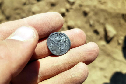 Primer pla de la moneda amb una inscripció de l'any 103 ANE que s'ha trobat al jaciment de l'Assut de Tivenys. Imatge del 12 de juliol del 2019 (horitzontal)