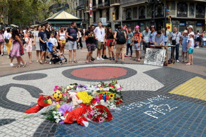 El mosaic de Miró a la Rambla amb flors i espelmes en honor a les víctimes de l'atemptat del 17-A.