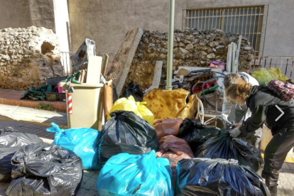 Imatge d'una voluntària acumulant la brossa recollida.