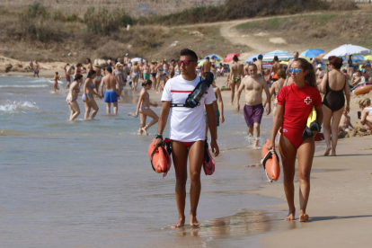 Dos socorristes de la Creu Roja patrullant per la platja de l'Arrabassada de Tarragona durant aquest agost.