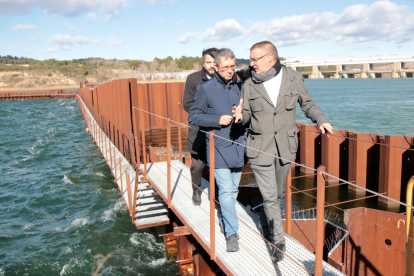 Pla general del secretari d'Estat de Medi Ambient, Hugo Morán, a l'esquerra, acompanyat per l'alcalde de Flix, Marc Mur, en la visita a la represa de les obres de descontaminació del pantà de Flix. Imatge del 28 de gener de 2019