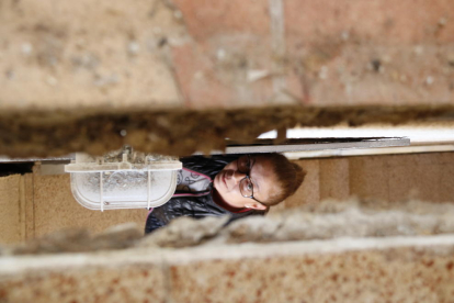 Una veïna observant a través d'una gran escletxa oberta a les escales del bloc de pisos on viu, al barri Centcelles de Constantí.