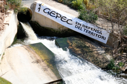 Imagen de la salida de las aguas de la depuradora de Reus, con un cartel de Gepec para denunciar que este caudal no se reutilice y se siga trasvasando agua del río Siurana en el pantano de Riudecanyes.
