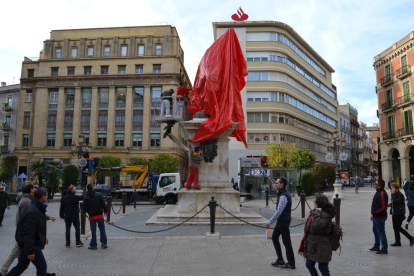 Imatge de l'estatua de la Plaça Prim coberta amb una tela vermella