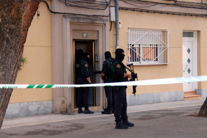 Varios agentes de la Guardia Civil en la puerta de una vivienda de la calle Goya de Sabadell donde están llevando a cabo un cacheo.