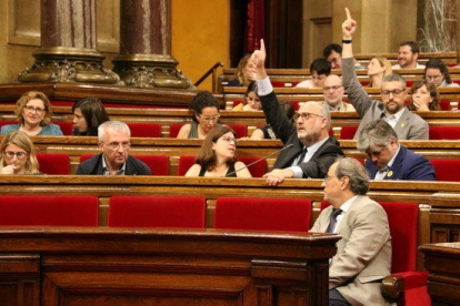 Eduard Pujol (JxCat) y Bernat Solé (ERC) votan afirmativamente durante el pleno del Parlament.