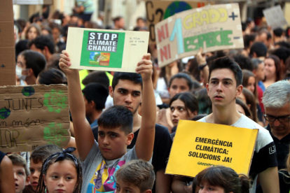 Plan|Plano medio de un niño y un chico mostrando carteles contra el cambio climático en la plaza de la Fuente de Tarragona, el 27 de septiembre del 2019
