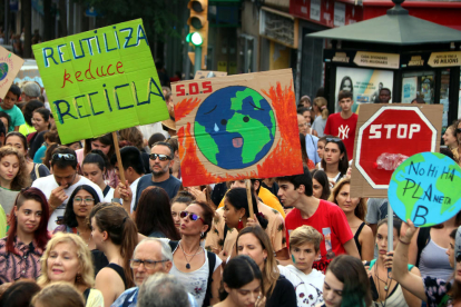 Pla tancat de diversos manifestants alçant cartells amb motiu de la manifestació sobre l'emergència climàtica a Tarragona, el 27 de setembre del 2019
